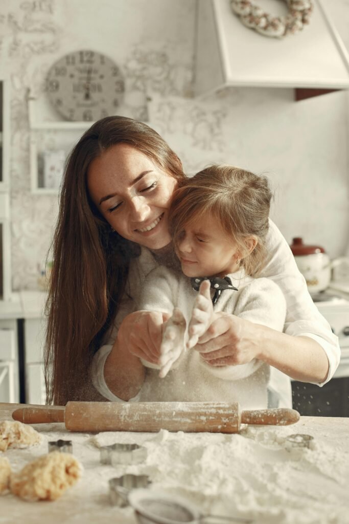 A joyful mother and daughter making cookies in a cozy kitchen setting.